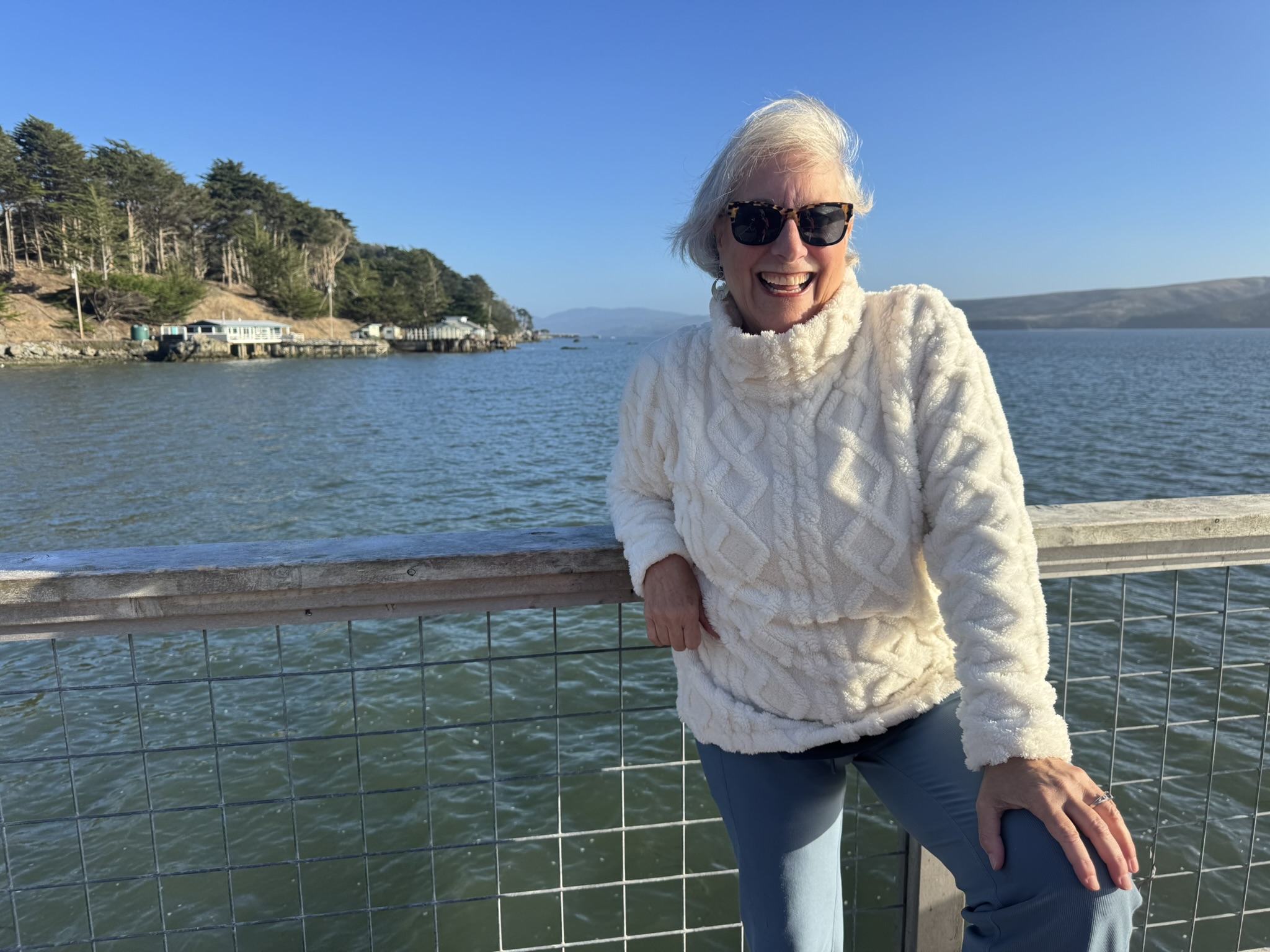 Illana laughing at a railing above the bay