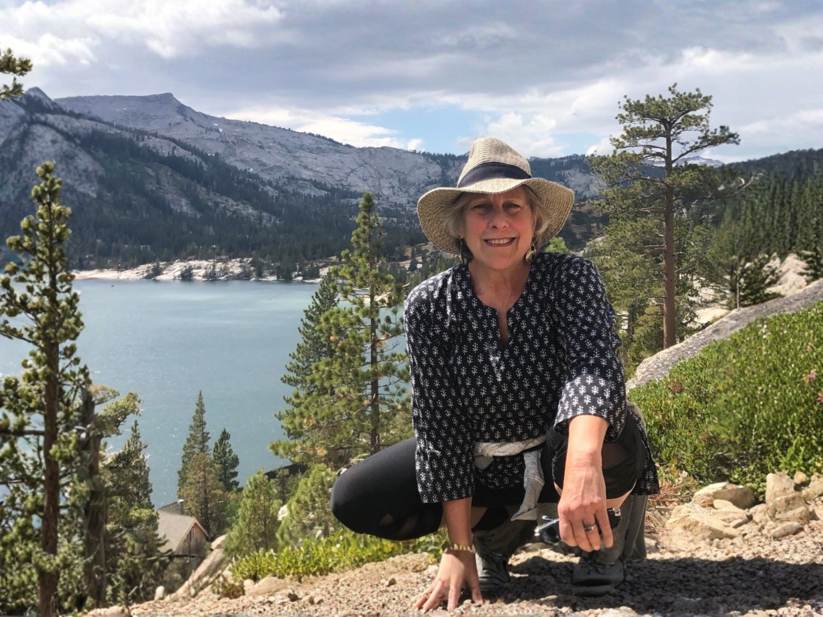 Illana Berger kneeling above a mountain lake