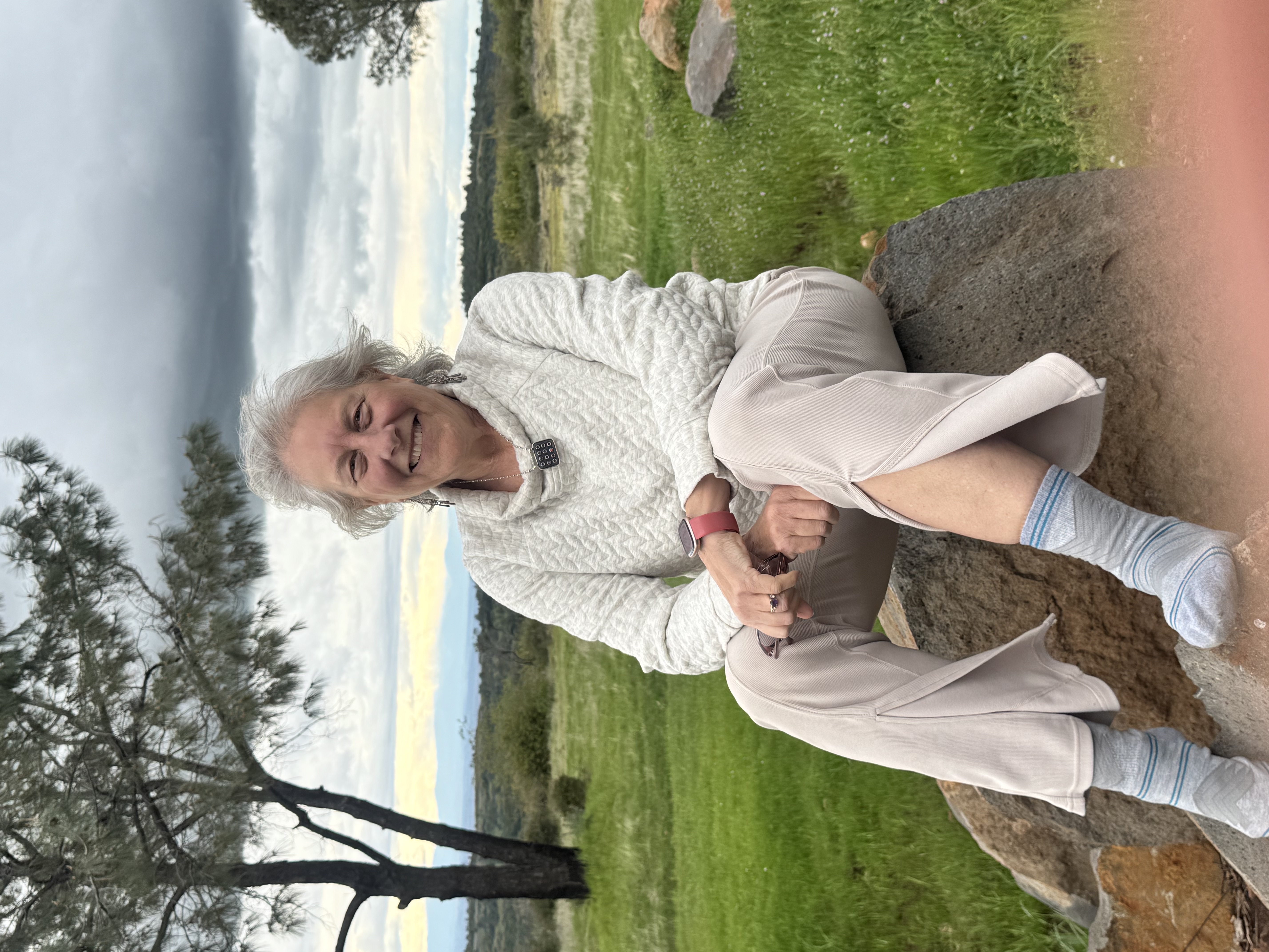 Illana on a boulder under a gathering sky